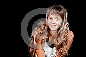 Smiling beautiful blue-eyed blonde girl in white dress on a black background