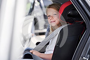 Smiling beautiful child in automobile safety seat