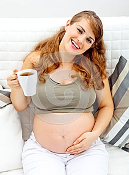 Smiling beautiful female holding cup of tea