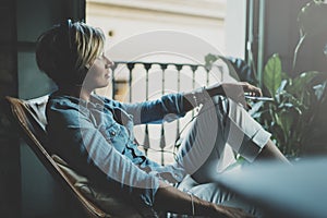 Smiling beautiful girl relaxing at home,playing music using smartphone and wearing sun glasses and modern headphones