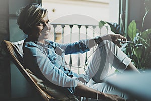 Smiling beautiful girl relaxing at home,playing music using smartphone and wearing sun glasses and modern headphones