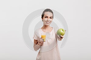 smiling beautiful girl showing green apple