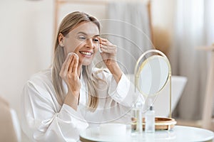 Smiling beautiful lady removing make up, using cotton pads