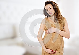 Smiling beautiful pregnant woman at home with big belly. Pregnancy and motherhood concept. Happy baby expectation. Interior