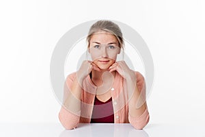 Smiling beautiful 20s blond woman sitting at sparse desk