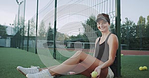 Smiling beautiful sportiv woman , before tennis game playing with a tennis ball in front of the camer.