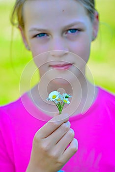 Smiling beautiful teenage girl with small bouquet of daisies