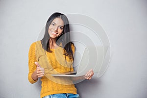 Smiling beautiful woman holding laptop