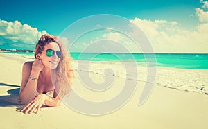 Smiling beautiful woman sunbathing on a beach