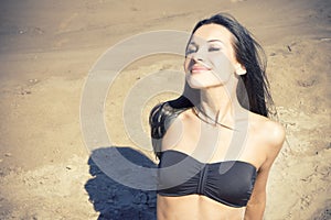 Smiling beautiful woman sunbathing on a beach