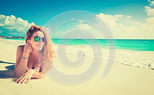 Smiling beautiful woman sunbathing on a beach photo