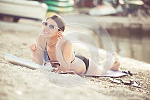 Smiling beautiful woman sunbathing in a bikini on a beach at tropical travel resort