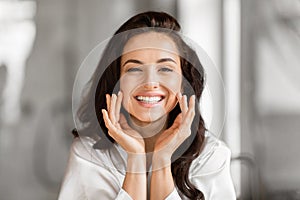 Smiling beautiful woman touching her face gently