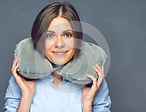 Smiling beautiful woman with travel pillow on neck.