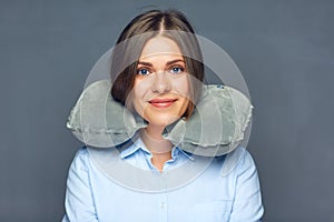 Smiling beautiful woman with travel pillow on neck.