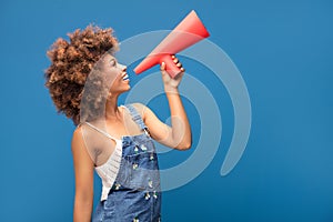 Afro young girl screaming by red megaphone.
