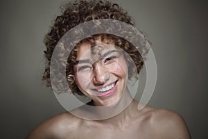 Smiling beautiful young freckled girl with curly hair, selective focus