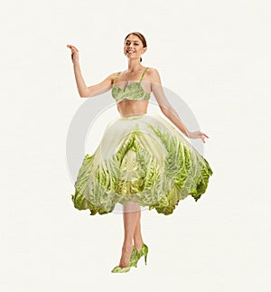 Smiling, beautiful, young girl with slim body wearing cabbage clothes over white background. Contemporary art collage.