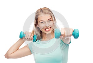 Smiling beautiful young sporty woman with dumbbell