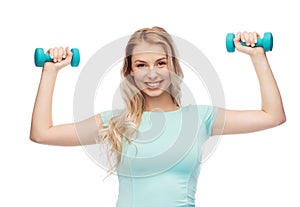 Smiling beautiful young sporty woman with dumbbell