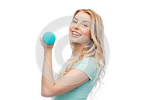 Smiling beautiful young sporty woman with dumbbell