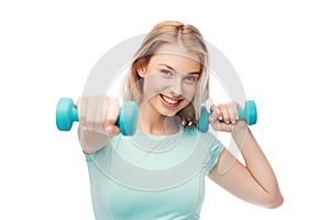 Smiling beautiful young sporty woman with dumbbell