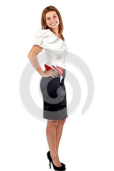 Smiling beautiful young woman in black and white dress standing