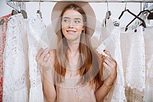 Smiling beautiful young woman standing in clothing store