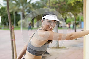 Smiling beautiful young woman using sport wear doing stretches while smiling at the camera