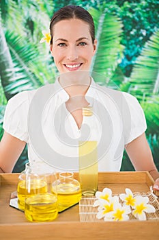 Smiling beauty therapist holding tray of beauty treatments