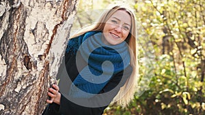 Smiling beauty young blond woman in autumn colorful Park on sunny day, enjoying autumn foliage with a smile. slow motion
