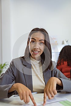 Smiling biracial businesswoman sitting at desk making video call in modern office