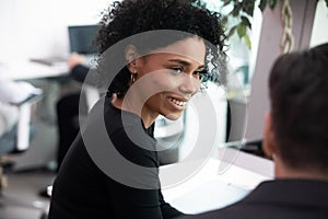 Smiling biracial employee talk with colleague in office
