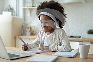 Smiling biracial girl watch video on laptop at home