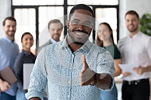 Smiling biracial male boss meeting new employee at workplace