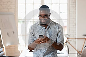 Smiling biracial male employee using cellphone in office boardroom