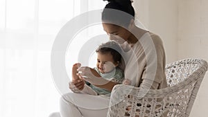 Smiling biracial mom play with little baby daughter