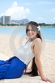 Smiling biracial teen girl leaning back relaxing in Waikiki, Haw