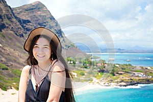 Smiling biracial teen girl with Hawaiian mountain and beach back