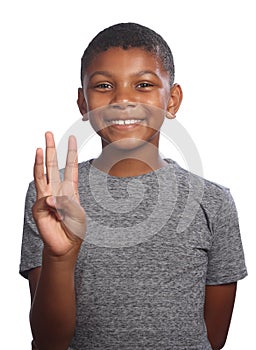 Smiling black boy showing number three on fingers