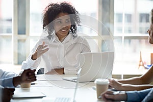 Smiling black businesswoman talk sharing ideas at company briefing photo