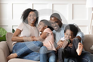 Smiling black family with kids having fun at home.