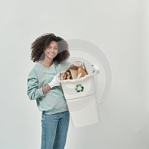 Smiling black girl holding dustbin with cardboard
