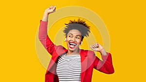 Smiling black girl listening to music and dancing