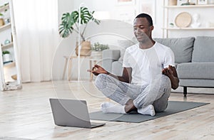 Smiling black guy having morning meditation at home