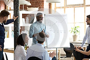 Smiling black leader or coach giving presentation at business meeting