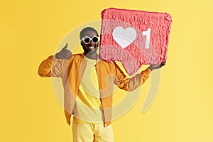 Smiling black man with like icon pinata showing thumbs up