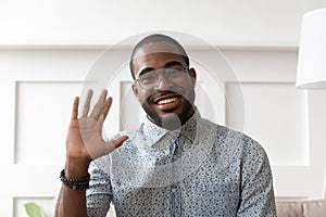 Smiling black man waving talking on video call