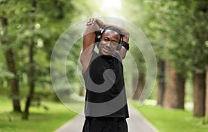 Smiling black sportsman enjoying exercising at park