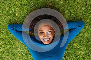 Smiling black woman lying on grass